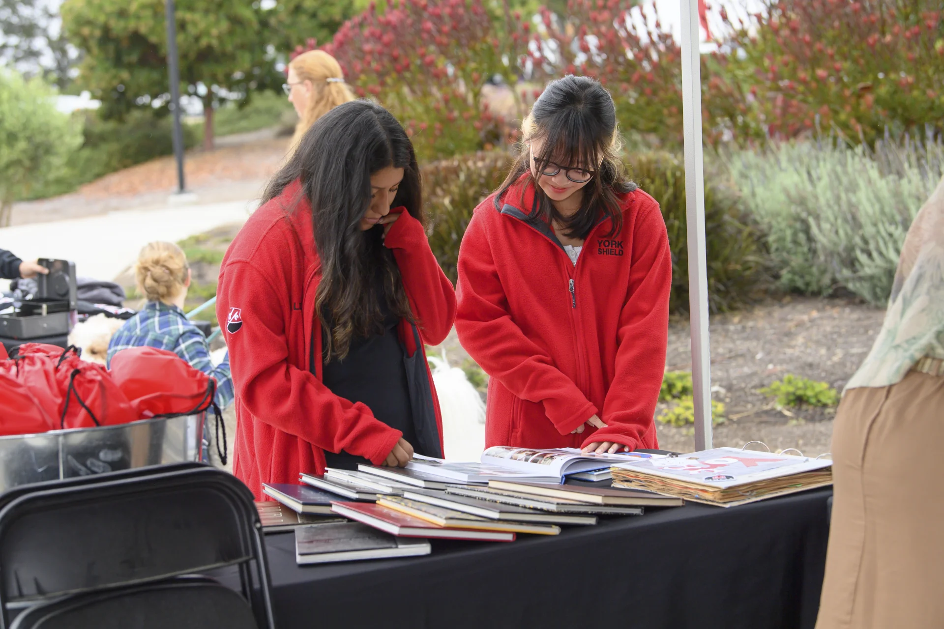 2 alumni looking at past yearbooks